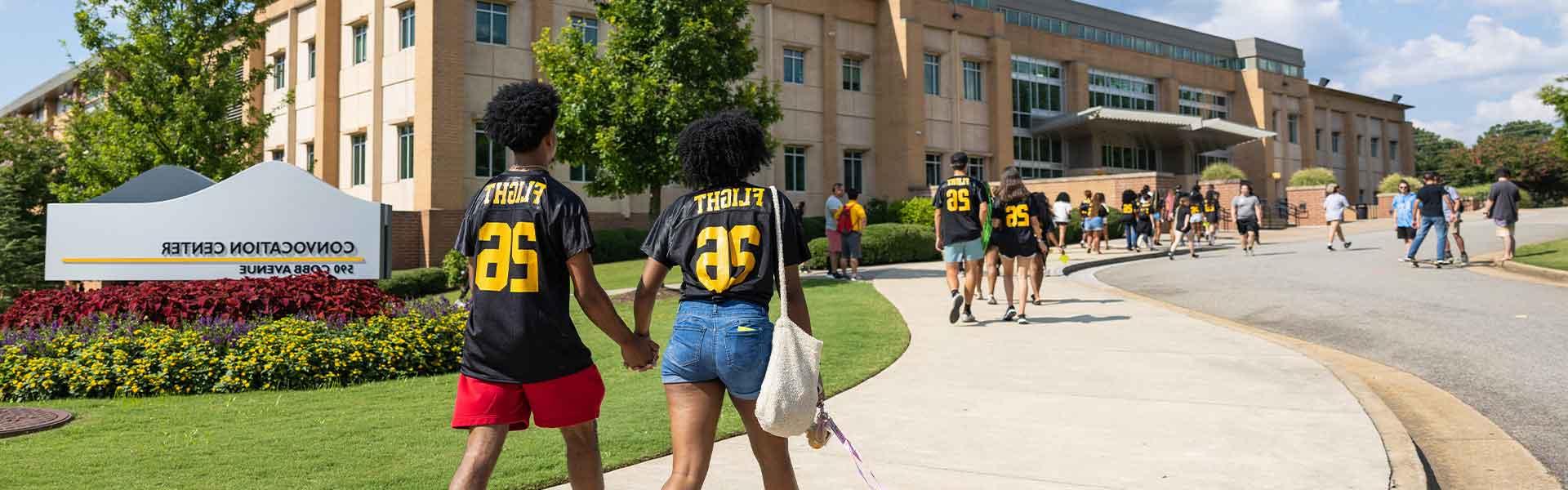 students in FLIGHT26 jerseys walking on campus